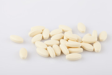 Fototapeta na wymiar Yellow pills on a white surface. Pills isolated on white background.