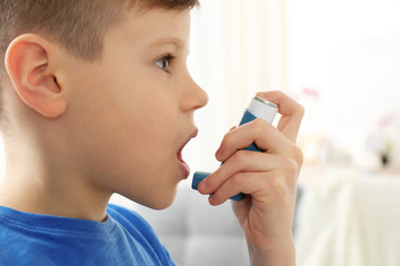 Little boy using asthma inhaler, closeup