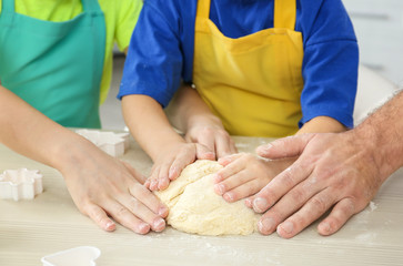 Man and two boys making dough, closeup