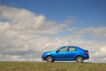 GOMEL, BELARUS - 16 April 2017: Beautiful blue car against the sky with clouds - obrazy, fototapety, plakaty