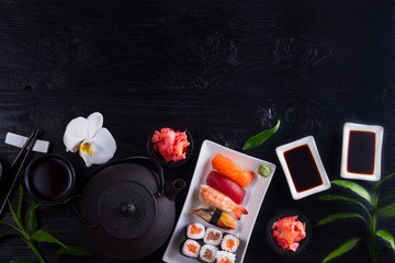 Japanese sushi dish border on black wooden background with copy space