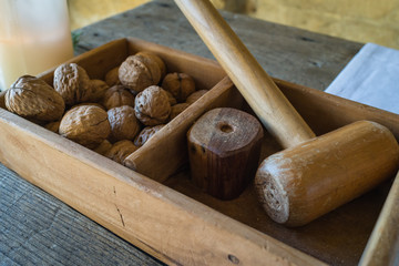 A wooden box with traditional wooden hammer to crack walnuts for italian breakfast