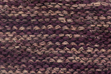 Abstract knitted purple background texture. Textile pattern of purple woolen handmade cloth. Macro of back loop wool winter fabric with geometric color ornament