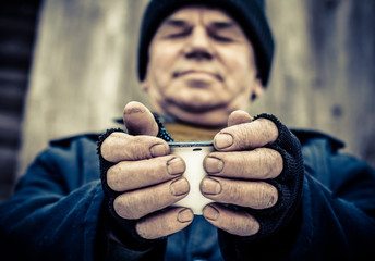 Dirty hands of a man clamped a metal Cup.
