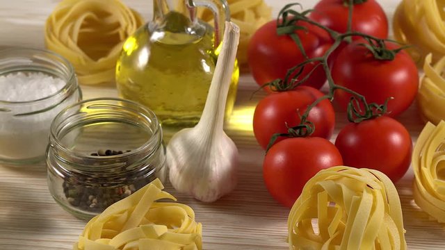 pasta, oil, tomatos and garlic on wooden background