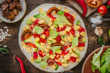 Tortilla with salad over it, surrounded by ingredients.