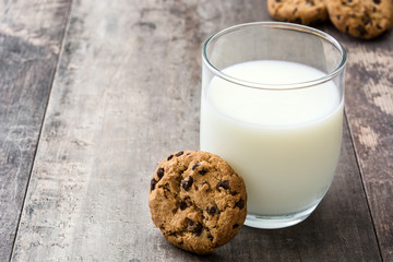 Chocolate chip cookies and milk on wooden table background
