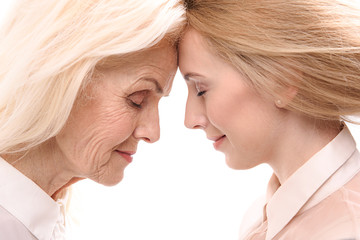 Old lady inclining forehead to younger woman