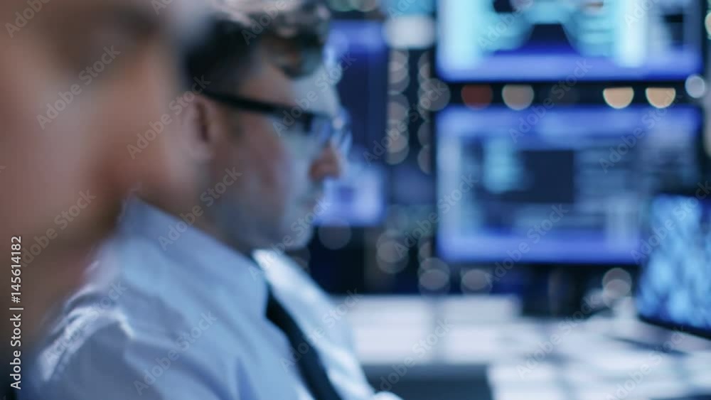 Poster In the System Control Center Team of Technicians Monitor System Stability. Close-up Faces Footage. Possible Air Traffic/ Power Plant/ Security Room Theme. Shot on RED EPIC-W 8K Helium Cinema Camera.