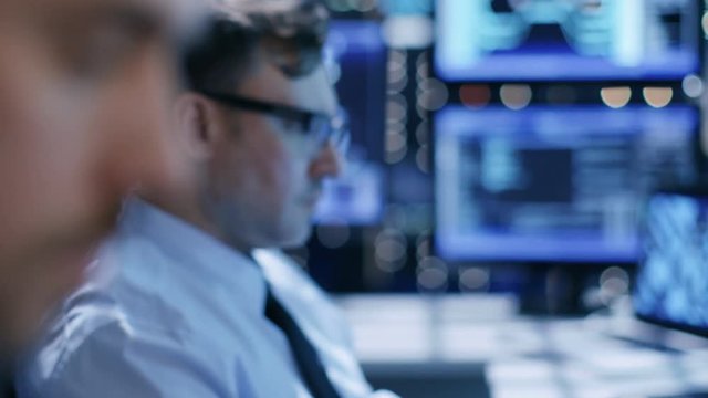 In the System Control Center Team of Technicians Monitor System Stability. Close-up Faces Footage. Possible Air Traffic/ Power Plant/ Security Room Theme. Shot on RED EPIC-W 8K Helium Cinema Camera.