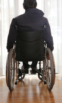 handicapped person in a wheelchair in his bedroom