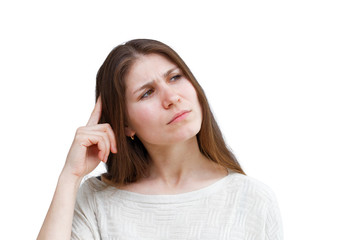 Fototapeta premium Portrait of a young brunette woman in a light jumper with a thoughtful expression looking away isolated on white background. Demonstration of various emotions.