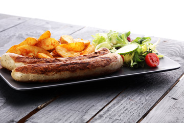 grilled sausages and potatoes and salad