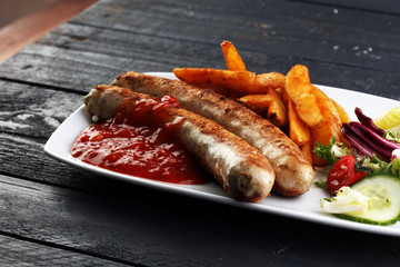 grilled sausages and potatoes and salad