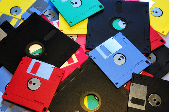 Old diskette 5 25 inches with 3.5 floppy disks of various colors. Background