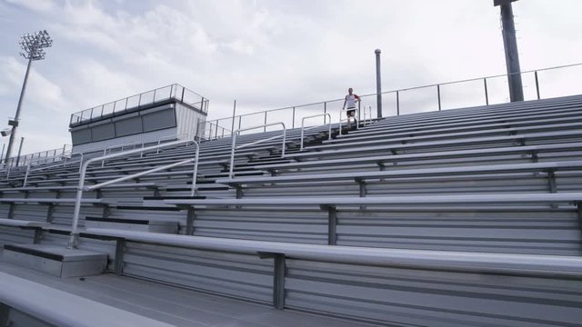 man running down bleachers
