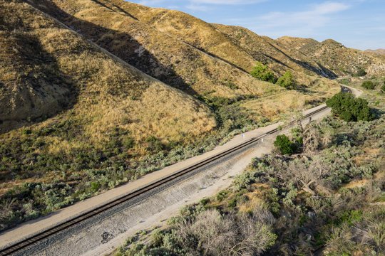 Railroad track line along the bottom of desert foothills in California.