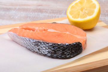 fresh raw salmon with spices and lemon on wooden cutting board. ready for cookin