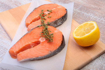 fresh raw salmon with spices and lemon on wooden cutting board. ready for cookin