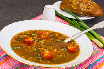 Spicy soup with curry, rice and grilled tomatoes