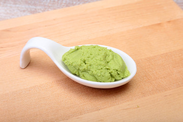 plate with Japanese wasabi sauce on wood background.