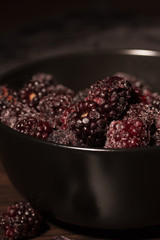 Frozen blackberries on a black plate
