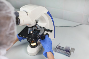 scientist looking through a microscope in a laboratory. scientist doing some research.