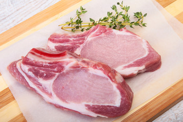 Raw pork chops, spices and rosemary on cutting board. Ready for cooking.