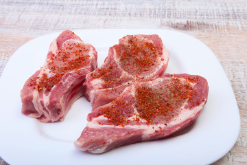 Raw pork chops, spices on cutting board. Ready for cooking.