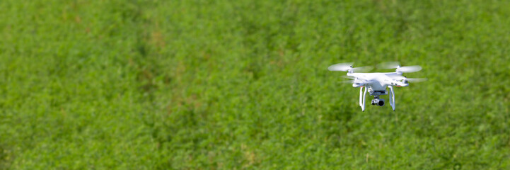 Quadcopter drone flying over a cultivated field
