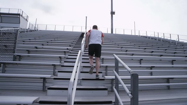 man doing sprints up bleachers