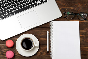 Office workplace with text space. Top view of office dark desk table with laptop, phone, tablet, notebook, and coffee cup. Top view with copy space Modern office workplace.
