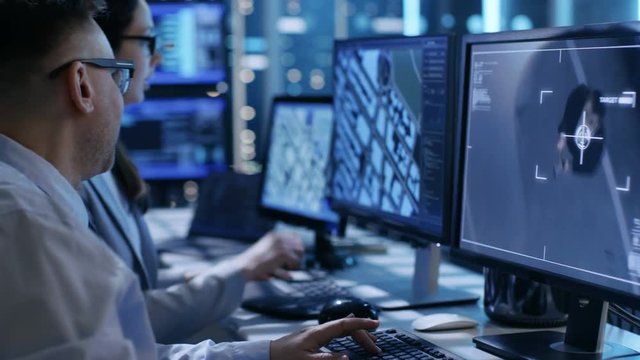 In Government Agency System Surveillance Center Employees Trace Criminal with Help of GPS. Their Room is Full of Displays with Various Data on Them. Shot on RED EPIC-W 8K Helium Cinema Camera.