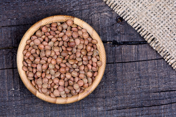 Bamboo bowl with brown lentils on table