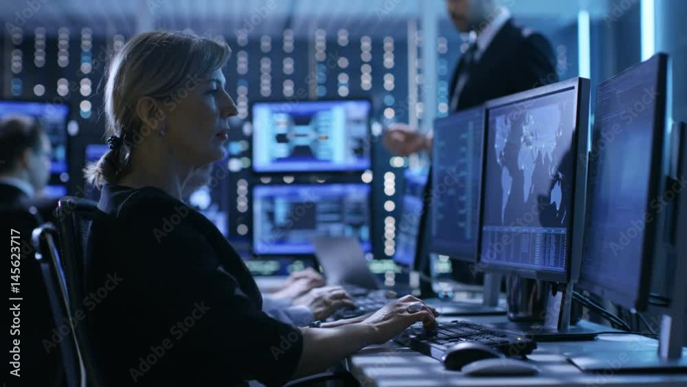 Aufkleber supervisor holds briefing for his employees in system control center full of monitors and servers. p