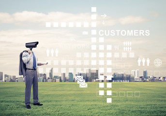 Camera headed man standing on green grass against modern citysca