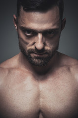 Fototapeta premium Portrait of muscle male model posing on grey background. Studio shoot.