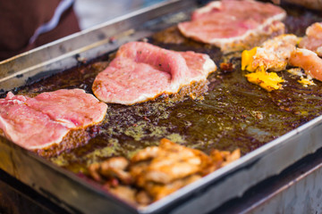Street food in Thailand. Pork cook with butter oil on hot plate.