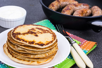 Hot pancakes with homemade sausage in frying pan