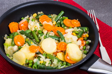 Potato with vegetables, fried in frying pan