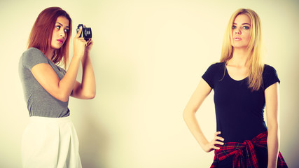 girl photographing blonde woman