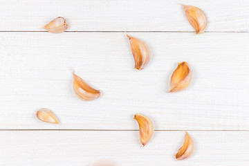 Top view, flat lay. Garlic cloves and garlic bulb on a white wooden table.