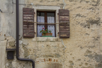 Brown wooden window shutters on the old stone house