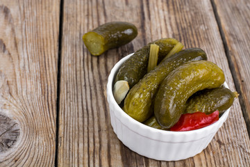 Marinated cornichons in white bowl