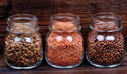 Different types of lentils in a jars on table