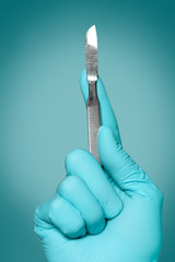 Hand of doctor with lancet on grey background