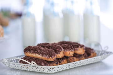 Delicious eclairs on metal tray, closeup