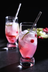 Refreshing cocktails with cranberry on dark table