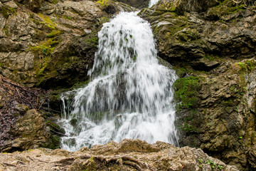 Obraz premium Wasserfall mit einem Felsen im Vordergrund bei Tag