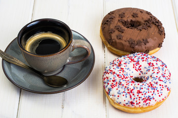 Delicious donuts on white wooden background